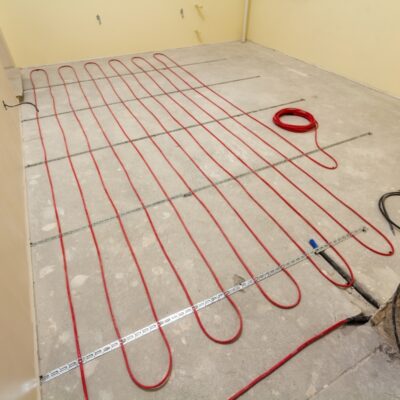 Podczas instalacji maty grzewcze rozłożone są na betonowej podłodze.