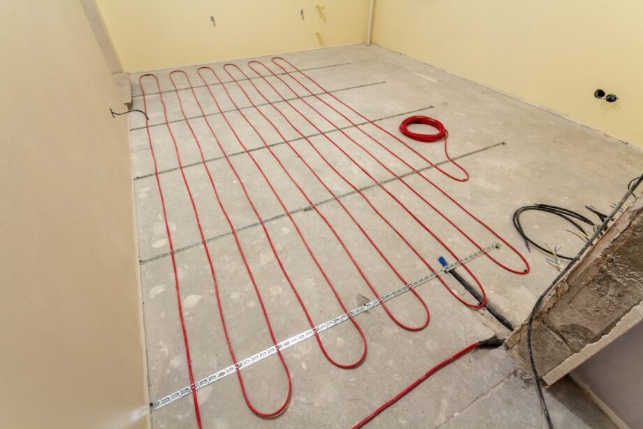 Podczas instalacji maty grzewcze rozłożone są na betonowej podłodze.